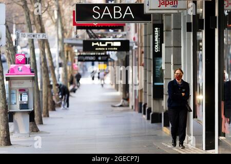 Melbourne, Australie, 6 août 2020. Une vue sur Collins Street alors qu'une femme portant un masque de visage se promènait et qu'un petit nombre de personnes sont vues en arrière-plan pendant la COVID-19 à Melbourne, en Australie. Les restrictions de l'étape 4 se poursuivent à Melbourne, car les permis de travail entrent en vigueur aujourd'hui à minuit. Cela vient du fait que 471 nouveaux cas de COVID-19 ont été découverts du jour au lendemain. Crédit : Dave Helison/Speed Media/Alamy Live News Banque D'Images