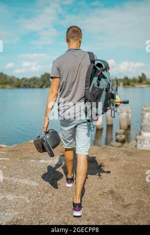 Homme avec un sac à dos sur un skateboard motorisé à une roue sur le trottoir Banque D'Images