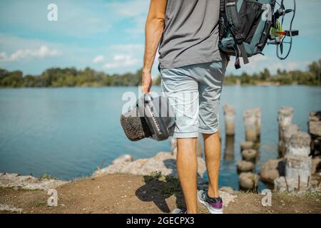 Homme avec un sac à dos sur un skateboard motorisé à une roue sur le trottoir Banque D'Images