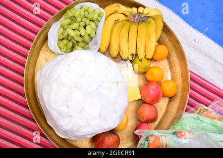 Banane, pomme, raisin et oranges, fruits et bonbons décorés dans une assiette en laiton, assortiment de fruits Banque D'Images