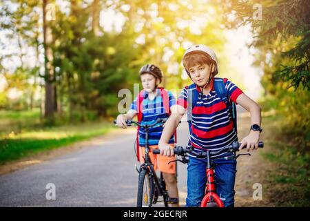 Des adolescents sur les vélos de la route asphaltée à l'école Banque D'Images