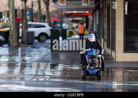 Bendigo, Australie, 21 août 2020. Un homme portant un masque conduit son scooter dans des rues vides pendant la COVID-19 à Bendigo, en Australie. Bien que le Conseil du Grand Bendigo n'ait eu que 27 cas de coronavirus actifs et qu'il soit en baisse, la ville est en train de faire face aux restrictions de l'étape 3, où les affaires sont en cours de fermeture, les préoccupations croissantes quant à la santé mentale et l'obligation de porter des masques faciaux, dans de nombreux cas lorsque les rues sont entièrement vides. Victoria a enregistré 179 nouveaux cas en une nuit et 9 autres sont morts, ce qui porte le nombre de morts dans les États à 385 personnes. Crédit : Dave Heis Banque D'Images