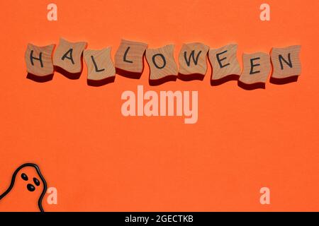 Halloween, mot en lettres de l'alphabet de bois avec fantôme dessiné à la main sur fond orange Banque D'Images