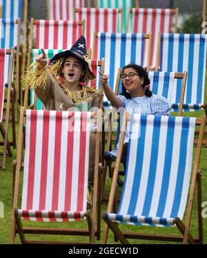 Aditi Jehangir en tant que Dorothy et Ewan Shand en tant que Scarecrow représentant le magicien d'Oz un des films populaires alignés pour le Festival du film de cette année dans la ville s'assoient sur des chaises longues dans une zone d'observation extérieure de la place St Andrew, dans le cadre du Festival international du film d'Édimbourg. Date de la photo: Jeudi 19 août 2021. Banque D'Images