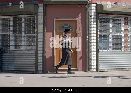 Un jeune adorateur juif orthodoxe retourne chez lui après les services du matin. Sur Lee Avenue à Williamsburg, Brooklyn, New York Banque D'Images