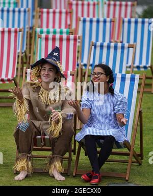 Aditi Jehangir en tant que Dorothy et Ewan Shand en tant que Scarecrow représentant le magicien d'Oz un des films populaires alignés pour le Festival du film de cette année dans la ville s'assoient sur des chaises longues dans une zone d'observation extérieure de la place St Andrew, dans le cadre du Festival international du film d'Édimbourg. Date de la photo: Jeudi 19 août 2021. Banque D'Images