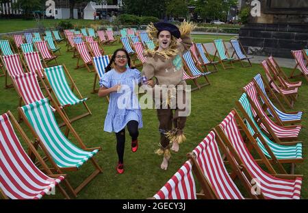 Aditi Jehangir comme Dorothy et Ewan Shand comme Scarecrow représentant le magicien d'Oz un des films populaires alignés pour le Festival du film de cette année dans la ville en marchant entre les chaises longues dans une zone d'observation extérieure de la place St Andrew, dans le cadre du Festival international du film d'Édimbourg. Date de la photo: Jeudi 19 août 2021. Banque D'Images