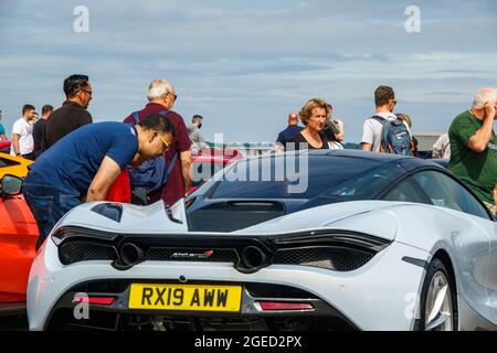 Farnborough, le 19th août 2021.Un homme regarde à l'intérieur d'une voiture de sport McLaren blanche au British Motor Show ; une exposition de sports automobiles, de voitures classiques, de voitures électriques et de supervoitures au Farnborough International Exhibition and Conference Centre. Banque D'Images