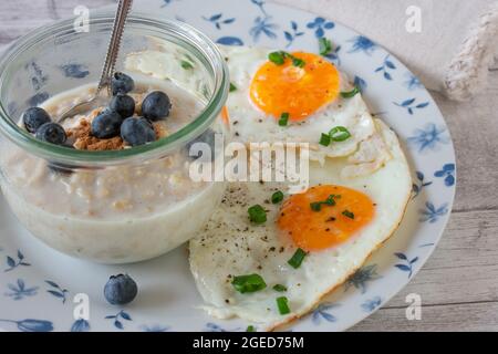 Petit-déjeuner maison avec avoine, bleuets et œufs sur l'assiette Banque D'Images
