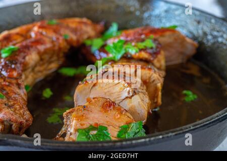 Plat de viande avec filet de porc ou filet de porc dans une délicieuse sauce au miel et au soja. Servi dans une poêle en fonte Banque D'Images