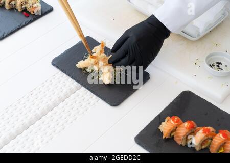 Chef masculin dans l'avocat de peeling uniforme pour sushi Banque D'Images