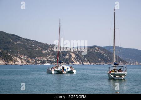 Segelyachten an der Küste. Touristen istmen am 19. Août 2021 dans die wunderschöne Stadt Santa Margherita im Levante Teil Liguriens. Santa Margherita und Ligurien bitechen durch die schöne Natur mit Meer, Hügeln, whewandert und geradelt werden kann und der schönen & bunten Architektur. Hafen von Santa Margherita legen viele Boote und Yachten an. * Voiliers à voile sur la côte. Les touristes visitent la belle Santa Marghrita dans la partie Levante de Ligurie, en Italie du Nord, le 19 août 2021. Les gens aiment Santa Margherita comme la Ligurie du tout à cause de la belle naïveté avec les collines / Banque D'Images