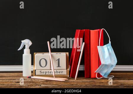 Calendrier avec livres et masque médical sur table en classe Banque D'Images