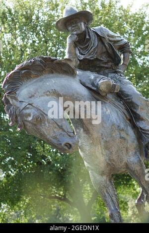 DALLAS, ÉTATS-UNIS - 23 août 2018 : une statue de Cowboy en bronze au Pioneer Plaza de Dallas, Texas, en arrière-plan d'arbres Banque D'Images