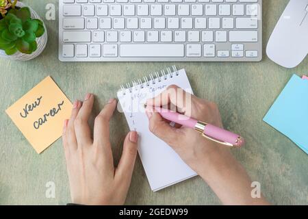 Bureau avec une note avec les mots NOUVELLE CARRIÈRE, bloc-notes vierge, stylo, clavier, cactus et mause sur une table en bois. Concept commercial et financier. Plat la Banque D'Images