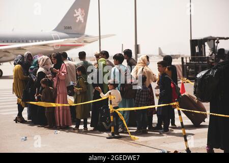 Les civils se préparent à monter à bord d'un avion lors d'une évacuation à l'aéroport international Hamid Karzaï, à Kaboul, en Afghanistan, en août 18. Les Marines des États-Unis aident le ministère d'État à faire un retrait ordonné du personnel désigné en Afghanistan. (É.-U. Photo du corps marin par le sergent d'état-major. Victor Mancilla) Banque D'Images