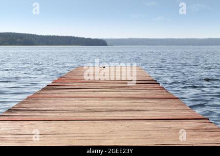 Jetée en bois vide par une journée ensoleillée, vue perspective, paysage côtier du lac Banque D'Images