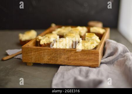 Gâteau savoureux avec banane et crème dans une boîte en bois. cheesecake sur la table. Gâteau doux au caramel. Banque D'Images