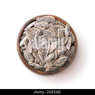 Vue de dessus des graines de tournesol salées dans un bol en bois isolé sur blanc Banque D'Images