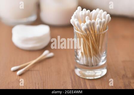 Bourgeons en coton naturel dans un récipient en verre sur une table en bois Banque D'Images