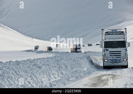 Camions roulant sur la route n° 1 enneigée en Islande, descendant du col de montagne d'Oxncheiadaldi Banque D'Images