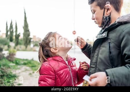 Portrait de deux enfants tout en mangeant et en partageant un morceau de chocolat Banque D'Images