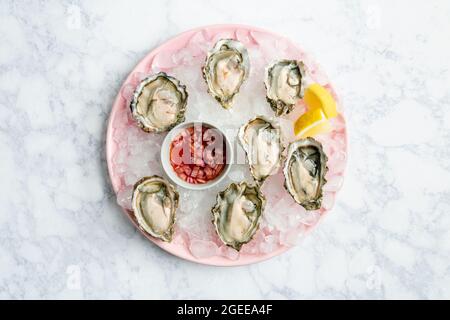 Vue sur les huîtres fraîches sur une assiette avec mignonette Banque D'Images