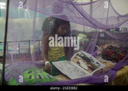 Un enfant a vu dessiner des dessins à l'intérieur d'une moustiquaire pendant la journée à l'hôpital pour enfants.le Bangladesh étant aux prises avec la pandémie de Covid-19, la dengue représente une grande menace pour les enfants du pays. À l'heure actuelle, la dengue sévère affecte la plupart des pays asiatiques et est devenue une cause majeure d'hospitalisations et de décès chez les enfants ainsi que chez les adultes dans ces régions, selon L'OMS. Dans des circonstances aussi désastreuses, certains habitants de Dhaka éclaient les incenses de répulsion des moustiques, même pendant la journée, pour éviter la maladie virale transmise par les moustiques. Banque D'Images