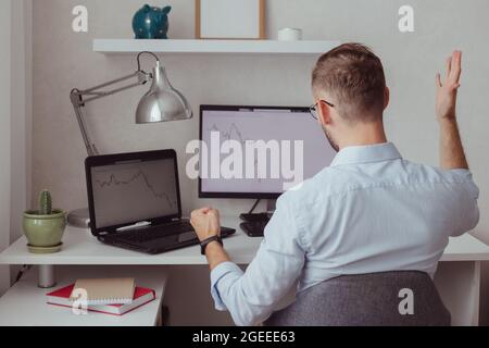 Homme en colère investisseur-Trader devant des moniteurs avec des graphiques. Correction boursière. Chute de la crypto-monnaie. Échec financier. Marché baissier. Forex Banque D'Images