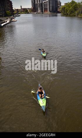 Vue aérienne des femmes pagayks pour l'exercice et le plaisir de l'extérieur sur les eaux de couleur marron de la rivière Milwaukee dans le centre-ville de Milwaukee, WI, États-Unis Banque D'Images