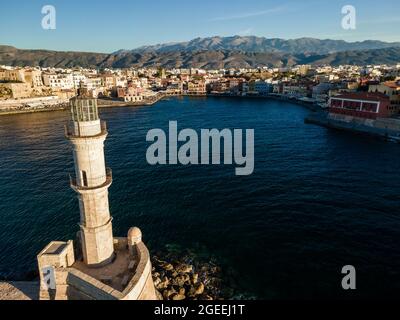 Vue aérienne par drone du phare vénitien emblématique à l'entrée du vieux port pittoresque de Chania au coucher du soleil sur l'île de Crète, Grèce. Banque D'Images