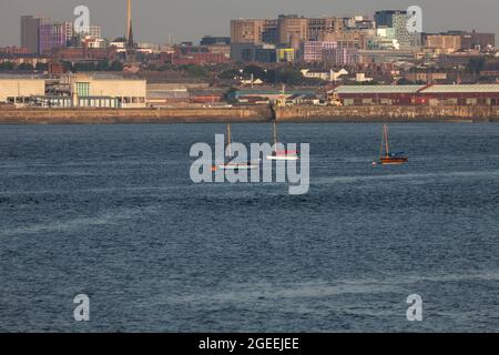 Des bateaux à voile amarrés près de l'embouchure du ferry Mersey, vus de New Brighton avec Liverpool en arrière-plan Banque D'Images