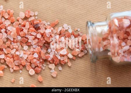 Sel rose de l'Himalaya dispersé dans une bouteille de verre, vue du dessus. Gros plan. Banque D'Images