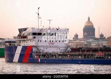 Bateau à remorqueurs poussant la Péniche sur la Neva avec la cathédrale St Isaac en arrière-plan, Saint-Pétersbourg, Russie Banque D'Images