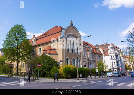 POZNAN, POLOGNE - 20 avril 2017 : un vieux bâtiment à côté d'un trottoir avec des piétons dans le centre-ville de Poznan, Pologne Banque D'Images
