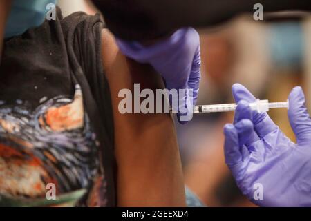 Columbus, États-Unis. 19 août 2021. Anyla Wade-Bacon, 13 ans, de Columbus, Ohio, reçoit le vaccin avant de retourner à l'école, au 3840 Kimberly Parkway. La clinique mobile de vaccination Wellness on Wheels d'OhioHealth rend visite aux communautés dont le taux de vaccination est plus faible et dont l'indice de vulnérabilité sociale est élevé afin d'offrir aux personnes des vaccins gratuits contre le coronavirus Pfizer (COVID-19). Crédit : SOPA Images Limited/Alamy Live News Banque D'Images