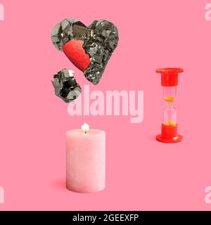 Pyrite minérale en forme de coeur et coeur rouge peint à l'intérieur, une bougie rose brûlante et un sablier sur fond rose. Gros plan Banque D'Images