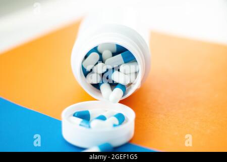 Les pilules ont débordé du pot. Capsules médicales sur la table. Produits pharmaceutiques. Prescription d'un médecin. Traitement de maladies avec des pilules. Banque D'Images