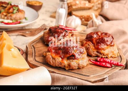 Planche en bois avec de délicieux bateaux à viande hachés sur la table Banque D'Images