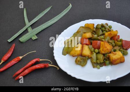 Plat de matar paneer mélange veg recette (cuisine indienne) et piments rouges sur fond noir Banque D'Images