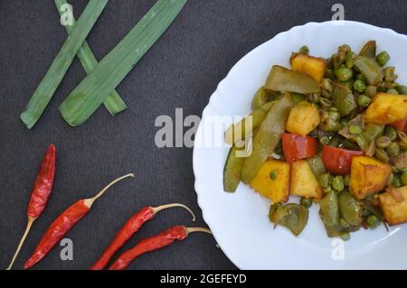 Plat de matar paneer mélange veg recette (cuisine indienne) et piments rouges sur fond noir Banque D'Images