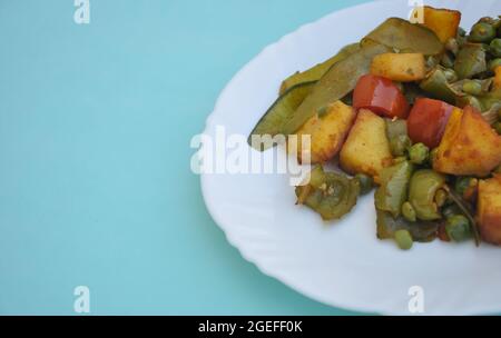 Photo du mélange de paneer matar veg (nourriture indienne) sur plaque blanche isolée sur fond bleu clair avec espace de copie Banque D'Images