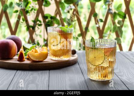 Mocktail d'été ou thé glacé à base de pêche, de lime et de menthe. Cocktail sans alcool ou boisson kombucha. Banque D'Images