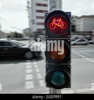 Petit feu de circulation pour les cyclistes avec un fond flou de la rue animée du centre-ville, feu supérieur rouge comme stop pour les cyclistes Banque D'Images