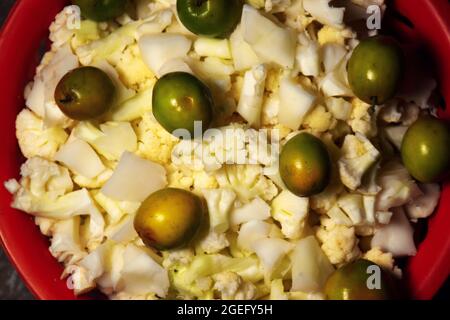 Baie et chou-fleur haché conservés dans un panier rouge utilisé pour les légumes et la salade Banque D'Images