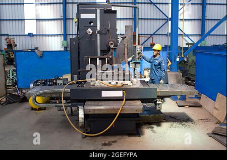 Un travailleur utilise une machine à aléser et à fraiser horizontale dans un atelier de fabrication. Banque D'Images