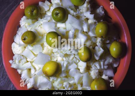 Baie et chou-fleur haché conservés dans un panier rouge utilisé pour les légumes et la salade Banque D'Images