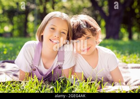 Portrait de famille gaie et attrayante frères et sœurs allongé sur un voile d'herbe duvel liant passer du temps à l'air frais jour ensoleillé à l'extérieur Banque D'Images