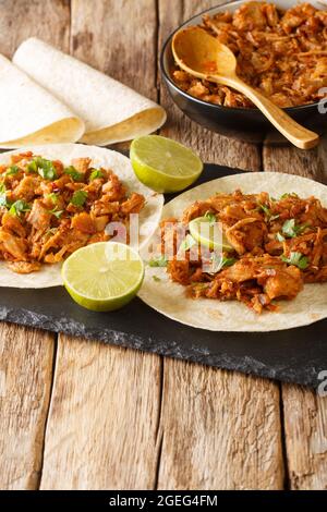 Porc sinaloen au Chili sauce Chilorio avec tortilla et lime dans le panneau d'ardoise sur la table. Verticale Banque D'Images