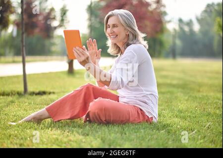 Femme saluant gestuelle devant la tablette Banque D'Images